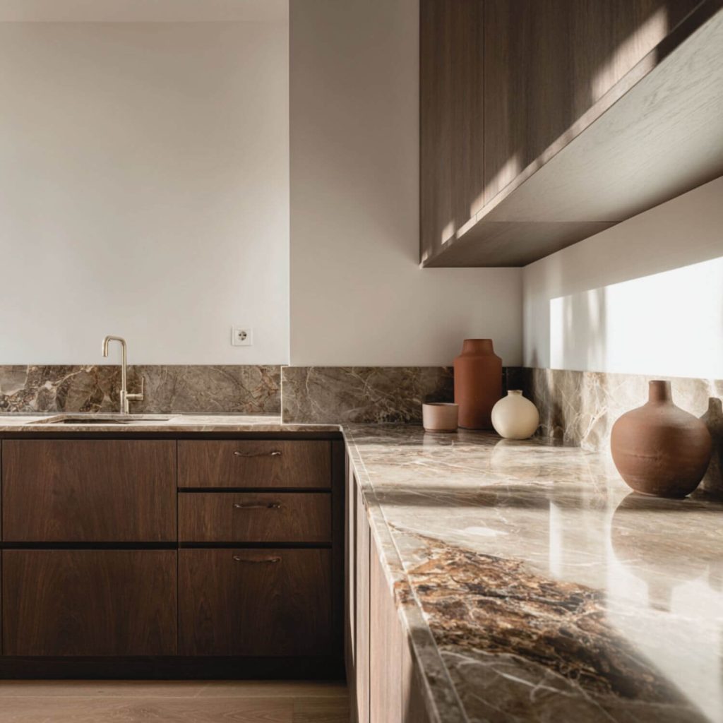 Cocina con encimera de piedra y muebles de madera en proyecto de interiorismo en Sevilla.
