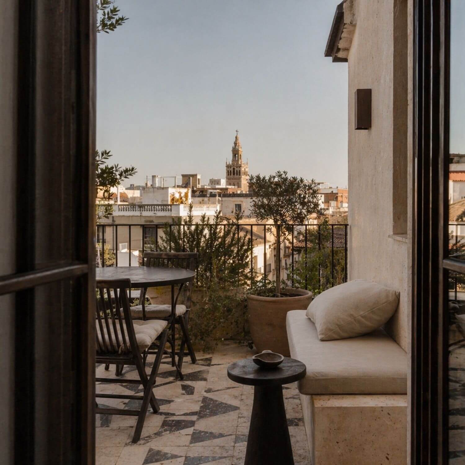 Terraza del Proyecto de interiorismo en Sevilla con banco de obra, pavimento geométrico y vistas a la Giralda de Sevilla. Proyecto Vigía.
