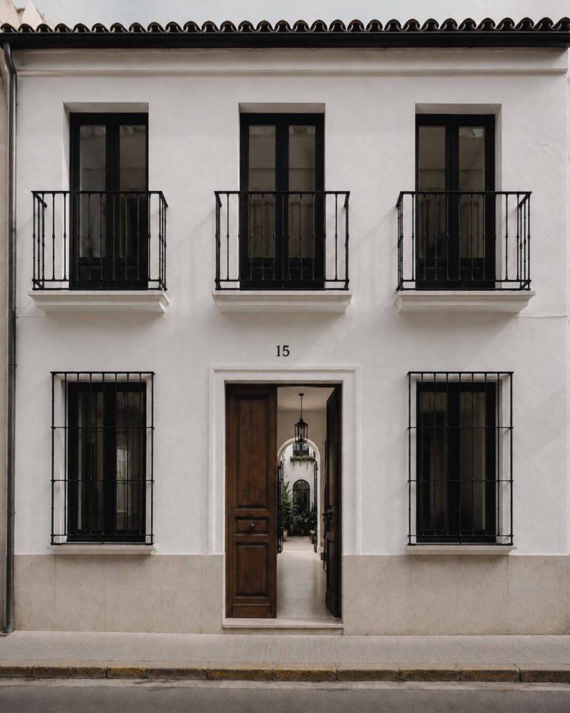 Fachada de casa andaluza contemporánea rehabilitada con patio interior y proyecto de interiorismo en Sevilla.