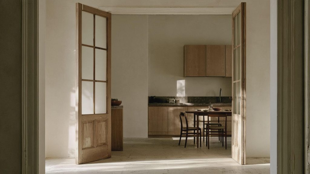 Pasillo con varias puertas abiertas y luz natural al fondo de la vivienda.