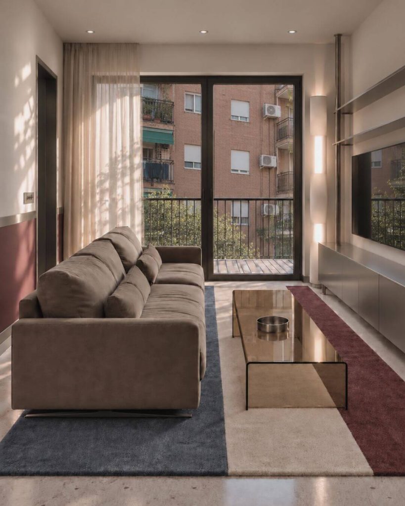 salón contemporáneo en sevilla con sofá neutro, acero cepillado y alfombra geométrica